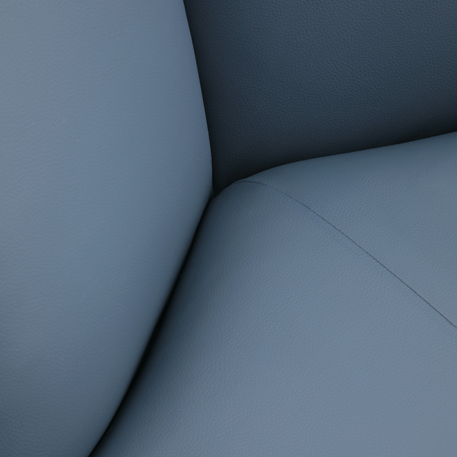 Contemporary lounge chair with soft blue upholstery, cushioned armrests, and curved black metal frame – designed for comfort in upscale hospitality or commercial spaces